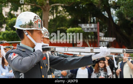 TAIPEI, Taïwan : Garde de cérémonie avec fusil et baïonnette à touriste à l'arrière-plan au Sanctuaire des martyrs de la révolution nationale Banque D'Images