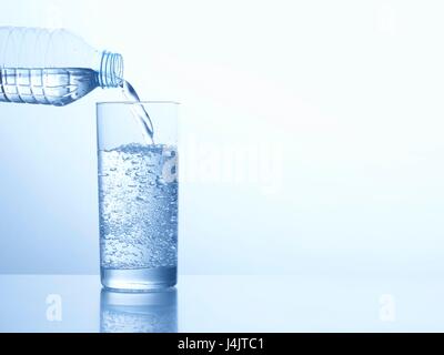 Verser de l'eau d'une bouteille dans un verre, studio shot. Banque D'Images