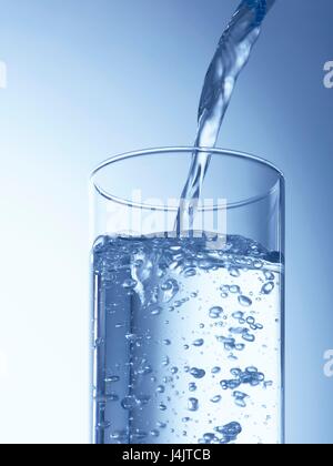 Verser de l'eau dans un verre, studio shot. Banque D'Images