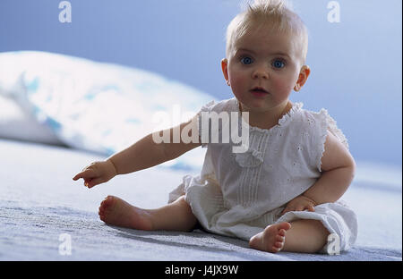 Caps, bébé, s'asseoir, de montrer l'intérieur, à la maison des gestes, l'enfant, bébé, fille, voir l'appareil photo, de couleurs vives, gaiement, main, soigneusement tendus, indiquer, corps entier Banque D'Images