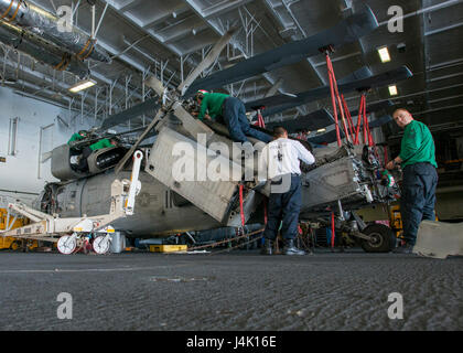 161109-N-FT110-013 OCÉAN PACIFIQUE (nov. 9, 2016) marins affectés à l'Escadron d'hélicoptères de combat de la mer (HSC) 4 'Black Knights' effectuer la maintenance d'un MH-60S Sea Hawk dans le porte-avions USS Carl Vinson (CVN 70) hangar bay. Carl Vinson est actuellement en cours d'exercice de l'unité de formation Composite (COMPTUEX) en préparation d'un déploiement prochain. (U.S. Photo de la marine du Maître de 2e classe d'Andre L. Roden/libérés) Banque D'Images