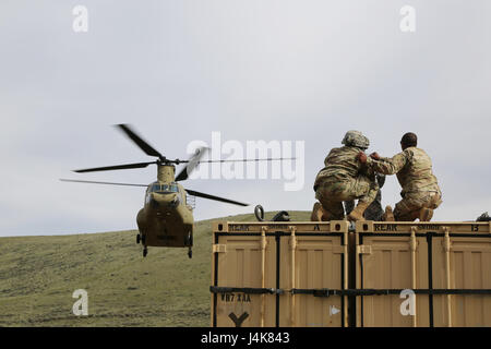 Le sergent de l'armée américaine. Chris Hearne, Air Assault Professeur de l'Académie guerrier fantôme, aide les soldats de la 92e compagnie de produits chimiques, 33e bataillon chimique, 48e Brigade chimiques, se préparer à un récipient au cours d'une opération à la charge de l'élingue Yakima, Yakima Training Center, Washington, 5 mai 2017. Les opérations de charge de l'élingue unités permettent d'accomplir leur mission en déplacement rapide des fournitures et de l'équipement, en contournant les obstacles de surface. (U.S. Photo de l'armée par le Sgt. Kalie Jones) Banque D'Images