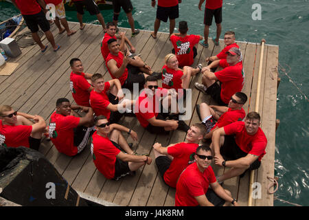 Les membres de l'unique du programme marin de l'équipe de bateau-dragon pose pour une photo alors qu'il était assis sur un quai en attente à bord d'un bateau dragon au cours de la 43e Festival Razafindrakoto Naha Dragon Boat Race le 5 mai dans la ville de Naha, Okinawa, Japon. Les Marines avaient 10 pratiques tout au long de un mois et demi avant la course. Pendant les pratiques les Marines ont travaillé sur leur technique et le rythme. Banque D'Images