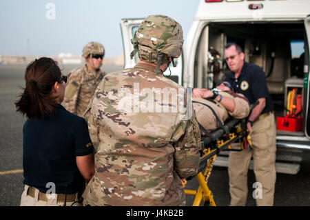 U.S. Army combat medics, avec le 86e Hôpital de soutien au combat, et les techniciens d'urgence médicale, avec groupe de soutien de secteur - Koweït, Service d'urgence conjointe, déplacer une victime simulée sur une ambulance, pendant un exercice de formation conjointe avec les Marines du milieu marin de l'escadron à rotors basculants - 364 (VMM-364), au Camp Arifjan, au Koweït, le 8 mai 2017. (U.S. Photo de l'armée par le Sgt. Christopher Bigelow) Banque D'Images