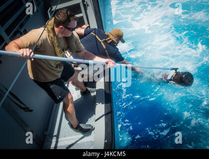 Les marins affectés à l'unité mobile de destruction des engins explosifs (5) 142 EODMU5 Peloton récupérer un véhicule sous-marin sans pilote sur une rivière côtière 1 Groupe Guam Détachement MK VI le bateau de patrouille dans l'océan Pacifique le 10 mai 2017. EODMU5 est actuellement en train de tester sa capacité à déployer des actifs de différentes plates-formes, y compris des hélicoptères et des bateaux de patrouille, d'augmenter son interopérabilité adaptative. EODMU5 mène la lutte contre les mines, engins explosifs improvisés, les opérations de sécurité rend les dangers d'explosion et désarme explosifs sous-marins comme les mines. (U.S. Caméra de combat de la marine photo par la communication de masse SP Banque D'Images