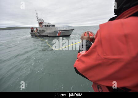 Seaman Apprentice Matthieu Biera, un membre de l'équipe de Coast Guard Station Bodega Bay, en Californie, est titulaire d'une ligne d'attrape au cours d'un exercice de transfert de pompe d'épuisement à bord d'un bateau de sauvetage à moteur de 47 pieds, 6 avril 2017. Équipage de bateau, formation de matelotage est conçu pour enseigner les méthodes approuvées et les procédures d'exploitation des bateaux de la Garde côtière canadienne. (U.S. Histoire de la Garde côtière canadienne par le maître de 3e classe Sarah Wilson) Banque D'Images