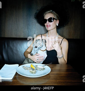 Restaurant, femme, élégamment, lunettes, soins, chien, touch, tableau, plaque, les jeunes huîtres, des verres, des bijoux, de l'alimentation, moules, spécialité, finesse, luxe, luxe, luxe, exclusivement vit, cher, richesse, haughtily, d'arrogance, l'arrogance, l'arrogance, Exaltiertheit, Greyhound, whippet, animal de compagnie, chien de compagnie, chien d'accompagnement, épris de l'animal, animal-affectueux, à l'intérieur, le style de vie, Ti6 Banque D'Images