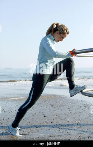 Plage, femme, la pratique de la gymnastique, de l'automne, sur le côté de 30 à 40 ans, des vêtements d'hiver, femme, jogger, jogging, course, fitness, formation, activité, sportily, sport, sport de masse, de la santé, le mouvement, la gymnastique, Dehnübungen distension, exercices, étirements, conscient de corps, consciente de la santé, plage de sable, mer, automne, hiver, aperçu Banque D'Images