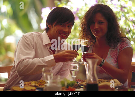 Couple, jeunes, tombe amoureux, wineglasses, terrasse de restaurant, s'asseoir, relever la vitre portrait , partenariat, respect, kick off, sourire, gaieté, heureusement flirt, amour, ensemble, le flirt, verres, vin, vin rouge, alcool, boissons, nourriture, aliments, d'une manière différente, restaurant, bar, terrasse, vacances, loisirs, l'été, à l'extérieur, le style de vie Banque D'Images