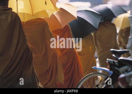 Cambodge, Phnom Penh, centre, moines, écrans d', mendier, recueillir vue arrière de l'Asie du Sud-Est, capitale, centre-ville, des hommes, des habitudes du moine, la foi, la religion, le bouddhisme, parapluies, parasols, de l'argent, les dons en espèces, dons de nourriture, de l'alimentation Banque D'Images