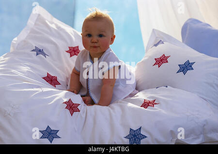 Lit, bébé, coussin, s'asseoir, soigneusement à l'intérieur, à la maison, les bébés, les enfants, voir l'appareil photo, gaiement, de couleurs vives, soigneusement, literie, draps star Banque D'Images