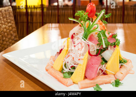 Une salade de nouilles et sashimi géant, servi avec une variété de poissons crus, des fruits et légumes. Banque D'Images