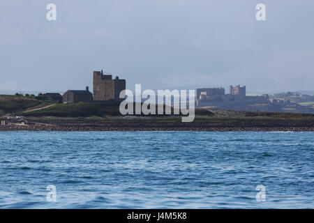 La Chapelle St Cuthbert et Castell's Tower sur l'île de Farne intérieure, et Château de Bamburgh, sur la côte de Northumberland en Angleterre. Banque D'Images