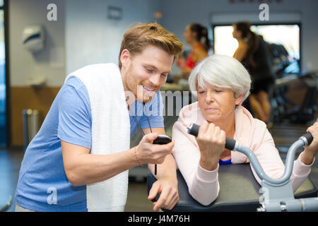 Entraîneur personnel montrant chronomètre temps de senior client Banque D'Images