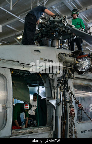 161109-N-FT110-009 OCÉAN PACIFIQUE (nov. 9, 2016) marins affectés à l'Escadron d'hélicoptères de combat de la mer (HSC) 4 'Black Knights' effectuer la maintenance d'un MH-60S Sea Hawk dans le porte-avions USS Carl Vinson (CVN 70) hangar bay. Carl Vinson est actuellement en cours d'exercice de l'unité de formation Composite (COMPTUEX) en préparation d'un déploiement prochain. (U.S. Photo de la marine du Maître de 2e classe d'Andre L. Roden/libérés) Banque D'Images