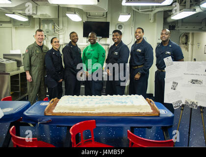 170117-N-LI768-134 en mer d'Oman (jan. 17, 2017) à partir de la gauche, le USS Makin Island (DG 8) Commandant Capt Mark A. Melson, Spécialiste du renseignement Chanel 1ère classe Newsome, de Los Angeles, les soldats du 2e classe Zemario Sheppard, de Sacramento, Californie, Technicien en électronique de l'Aviation 1re classe Jimmie Carter, de Milwaukee, l'entretien des 1ère classe Administrationman Jonathan Webb, de Detroit, le lieutenant j.g., Jason McClinton, de Chicago, et Master Chief Corpsman hôpital Robert fleurs, de Little Rock, Ark., préparer pour couper un gâteau au cours d'une célébration de Martin Luther King sur t Banque D'Images