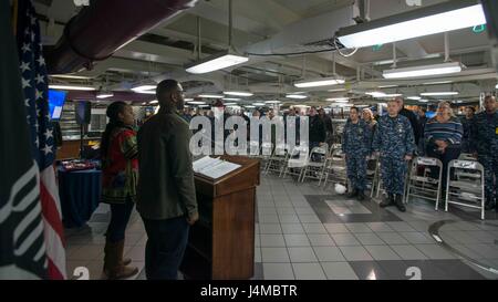 170223-N-AC117-036 Yokosuka, Japon (fév. 23, 2017) marins au garde à vous tandis que le spécialiste des opérations de 2e classe (SW/AW/IW) Christina Jackson, de Philadelphie, Pennsylvanie, chante l'hymne national lors d'une célébration du Mois de l'histoire afro-américaine sur le mess arrière ponts de la Marine a seulement l'avant-déployé, porte-avions USS Ronald Reagan (CVN 76). Ronald Reagan, le navire amiral de CSG 5, fournit une force prête au combat qui protège et défend les intérêts de maritime collective de ses alliés et partenaires dans la région du Pacifique-Indo-Asia. (U.S. Photo par marine Spécialiste de la communication de masse Banque D'Images