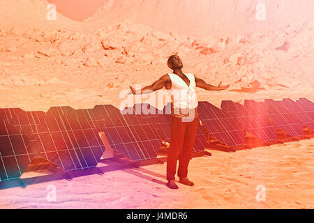 Homme debout sous le soleil de désert près de panneaux solaires Banque D'Images