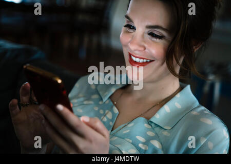 Woman texting on cell phone in the dark Banque D'Images