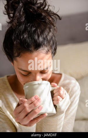 Hispanic woman drinking coffee Banque D'Images