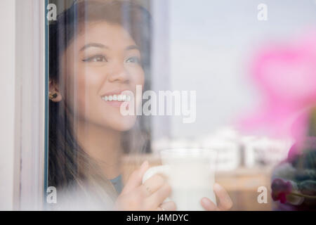 Mixed Race woman drinking coffee derrière Banque D'Images