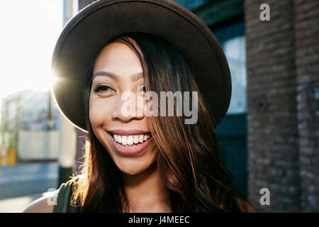 Portrait of smiling young woman posing in city Banque D'Images