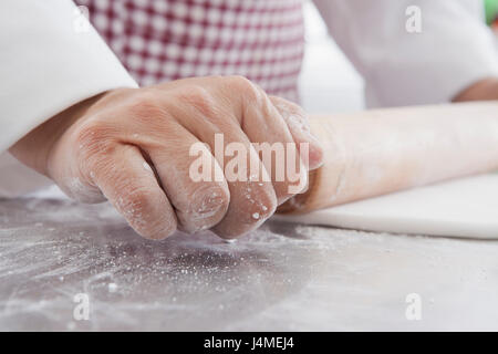 Mains de femme Hispanique à l'aide de rouleau à pâtisserie sur la pâte Banque D'Images