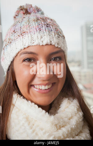 Portrait of smiling Hispanic woman wearing hat and scarf Banque D'Images