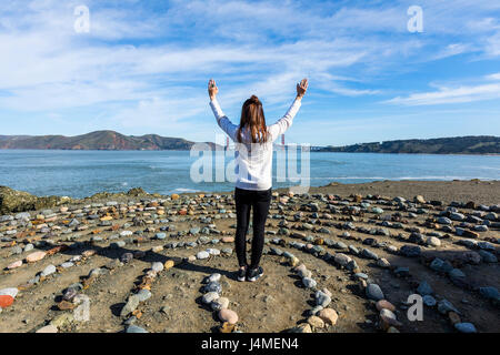 Caucasian woman standing in circle de rocks near ocean Banque D'Images