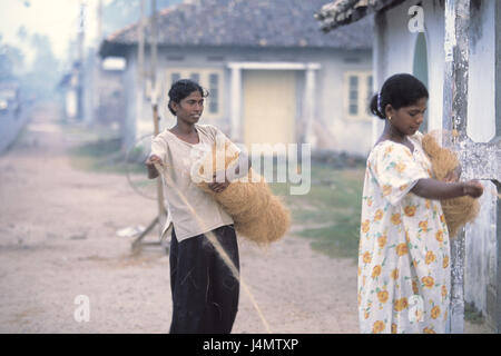 Sri Lanka, Hikkaduwa, femmes, fibres de palmier, de câblodistribution pour la production d'Asie, l'Asie du Sud, Etat insulaire, Sri Lanka Prajatantrika Samajavadi Janarajaya, Island, de l'économie, de la production, de fibres de palmier, fibres naturelles, fibres, naturelles, faire pivoter, corde, câble, produit naturel, matériau naturel, travail, Sri-Lankerinnen, de teint basané, deux, sourire Banque D'Images