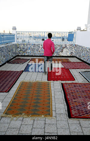 Tunisie, Tunis, boutique de tapis, du toit-terrasse, tapis, l'homme, vue de dos, Banque D'Images