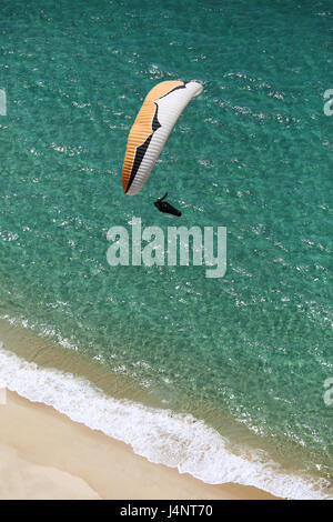 Un pilote de parapente voler au-dessus de l'Aberta Nova de surf à la plage. Banque D'Images