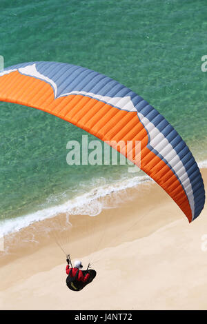 Un pilote de parapente voler au-dessus de l'Aberta Nova de surf à la plage. Banque D'Images