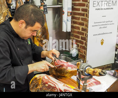 Un homme de race blanche à la trancheuse à jambon de Serrano spécialité coupe Jambon Iberico leg Central Market Mercado Central Valencia Banque D'Images