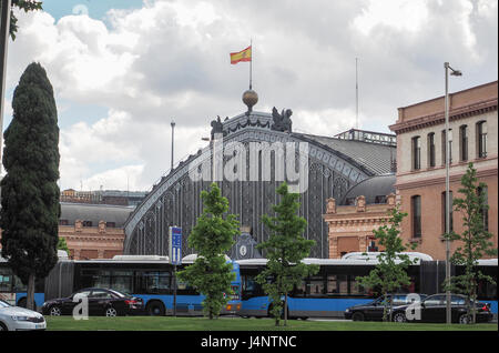 Une vue de l'extérieur de la gare d'Atocha, Estacion de Atocha, métal verre, bus passant, battant pavillon espagnol, Madrid, Espagne Banque D'Images