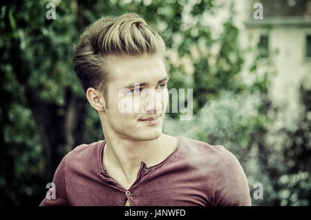 Jolie blonde aux yeux bleus, jeune homme fumeur Banque D'Images