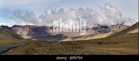 Matin sur l'autoroute de l'Leh-Manal : la route asphaltée qui passe par le haut désert, dans l'arrière-plan les montagnes ensoleillées, Dawn et puissant cumulus c Banque D'Images