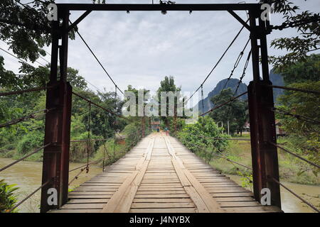 Vang Vieng, Laos-October 13, 2015 : Des femmes de la Croix-Rouge à pied du pont à péage de l'article 2 sur la rivière Nam Song marcher depuis le village d'un côté à la ri Banque D'Images