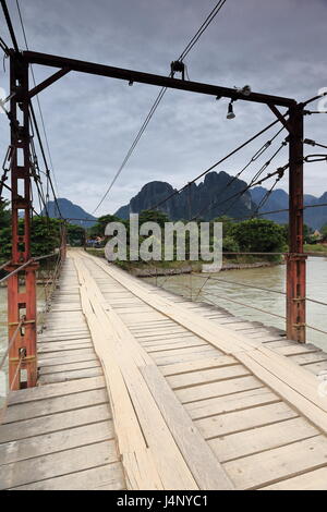 Vang Vieng, Laos-October 13, 2015 : femme locale traverse à pied le pont à péage de l'article 1 sur la rivière Nam Song à pied de la côté village au Banque D'Images