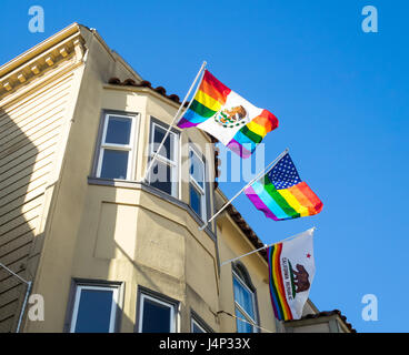 Un arc-en-ciel drapeau mexicain, rainbow drapeau américain, et la Californie flag suspendu à un fenêtre d'un immeuble dans le quartier Castro de San Francisco Banque D'Images