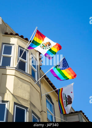 Un arc-en-ciel drapeau mexicain, rainbow drapeau américain, et la Californie flag suspendu à un fenêtre d'un immeuble dans le quartier Castro de San Francisco Banque D'Images