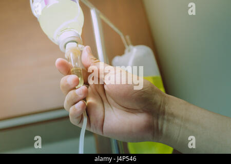 Close up hand régler perfusion IV saline pour patient in hospital Banque D'Images