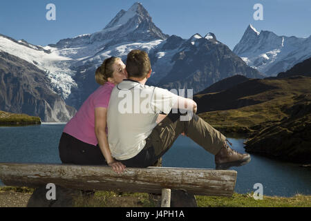 Couple, tombe amoureux, les jeunes, de 20 à 30 ans, s'asseoir, banque, Kiss, panorama alpin, lac de montagne, la Suisse, les Alpes Bernoises, Grindelwald, brook Alpsee, modèle libéré, Banque D'Images