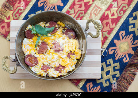 Oeufs au plat avec pepperoni et feuilles de menthe fraîche Banque D'Images