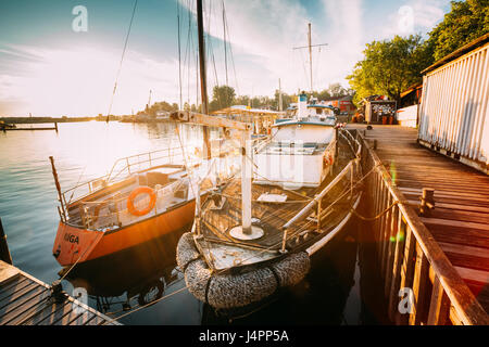 Riga, Lettonie - 1 juillet 2016 : Riga, Lettonie. Vieux Bateau et la location à la ville Pier baie portuaire et le quai en été ensoleillé le soir. Réflexions à partir de la B Banque D'Images