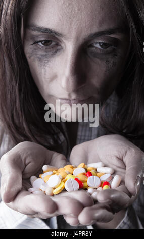 Pills in women's hands sur fond sombre. Se concentrer sur les pilules Banque D'Images