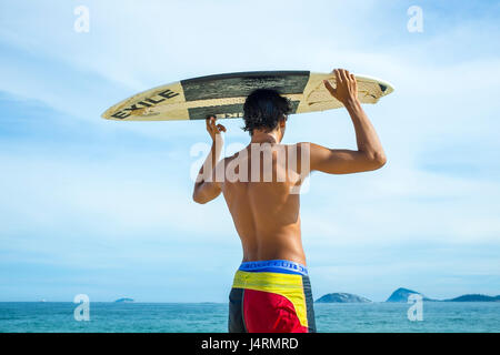 RIO DE JANEIRO - Février 5, 2017 : un jeune Brésilien se distingue de la recherche d'ondes avec son toit de skimboard sur la plage d'Ipanema. Banque D'Images