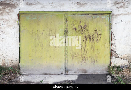 Rusty fermé porte verte en béton blanc, mur de garage télévision texture de fond photo Banque D'Images