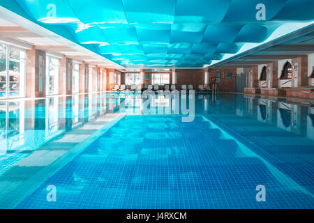 Piscine couverte avec toit ondulé bleu. La surface de l'eau claire et calme Banque D'Images