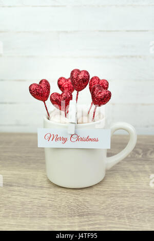 Message de vœux sur du papier blanc clipsé sur le café tasse avec des paillettes coeur rouge Banque D'Images